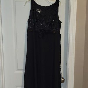 Sleeveless black high waisted dress with sequined top and sash with bow.